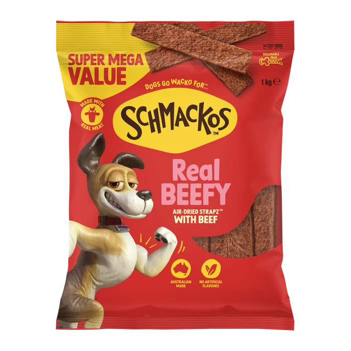 A bag of Schmackos Real Beefy dog treats, featuring a bright red and yellow package with a cartoon dog illustration and visible beef strips inside.