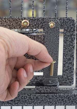 Hand holding a small metal screw next to a leopard print handbag with a metal clasp at Pet Servo