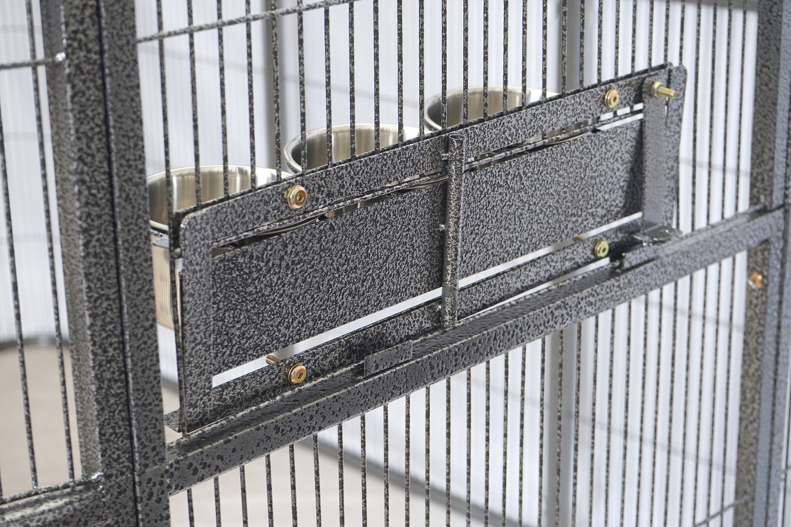 Bird cage with a perch and two small bowls inside at Pet Servo