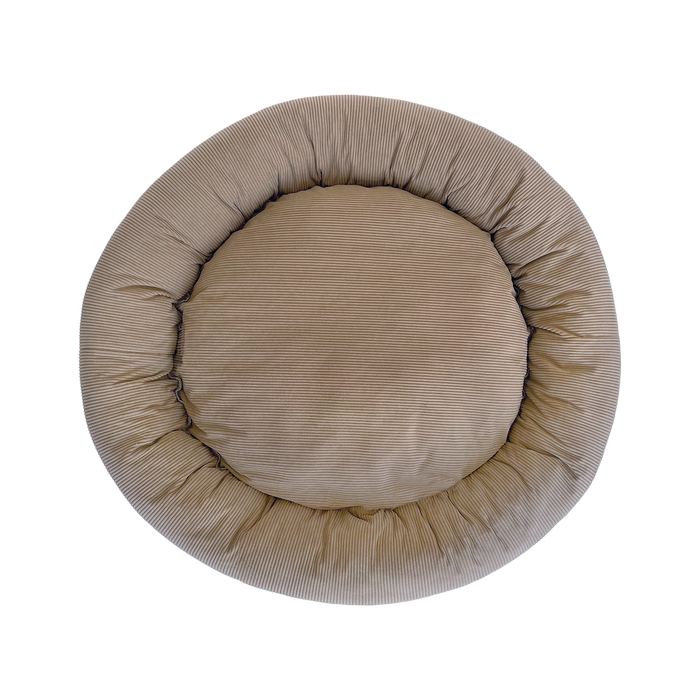 Round beige pet bed on a white background