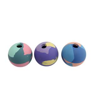 Three spherical decorative objects with circular cutouts at the top, shown side by side on a plain white background. Each sphere has a multicolor painted design in teal, pink, purple, yellow, and blue tones.