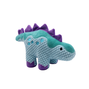 A knitted dinosaur toy with a light blue body, purple spikes along its back, and purple feet, shown on a plain white background.