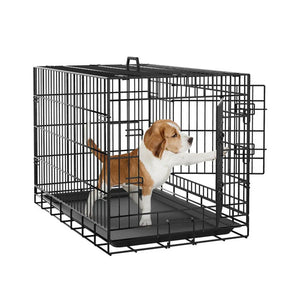 Dog inside a black metal crate on a white background