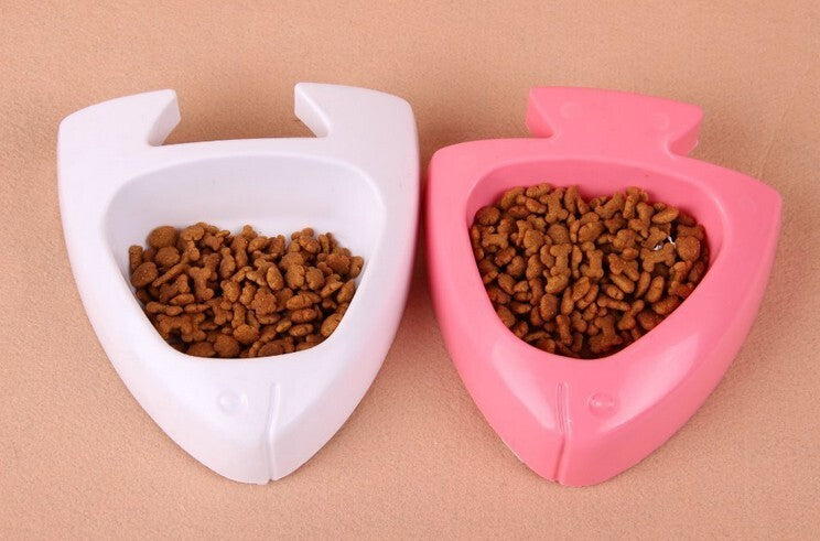 Two heart-shaped pet bowls, one white and one pink, filled with pet food on a beige background at Pet Servo