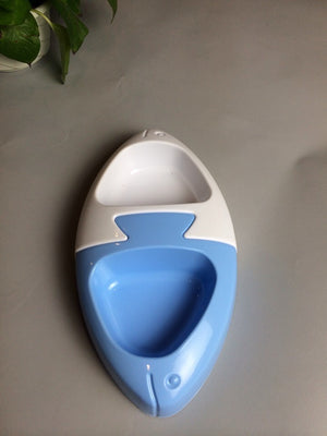 Blue and white pet potty trainer on a gray surface with a plant in the corner at Pet Servo