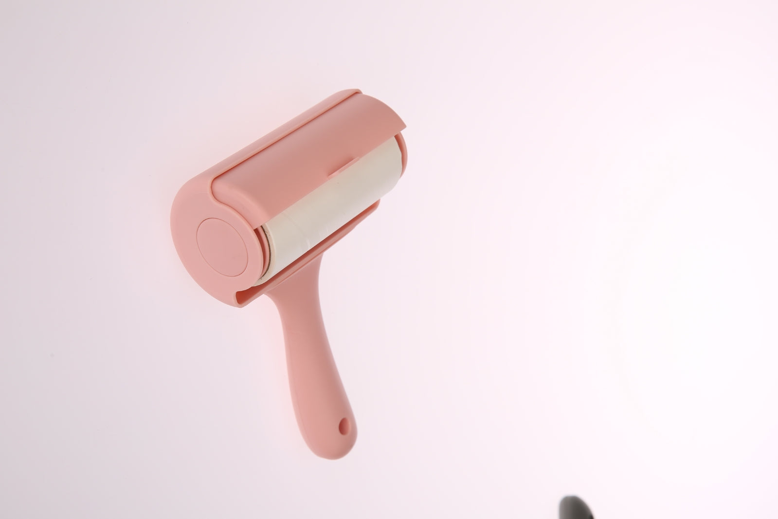 Pink pet hair remover on a light pink background at Pet Servo