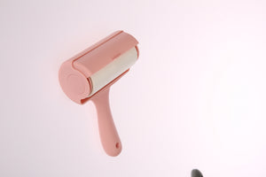 Pink pet hair remover on a light pink background at Pet Servo