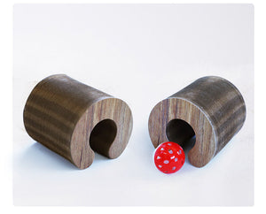 Two wooden cylindrical cat toys with a red ball between them on a white background at Pet Servo
