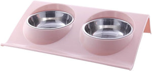 A pink elevated double pet feeder and water bowl stand with two stainless steel bowls, shown on a plain white background at Pet Servo