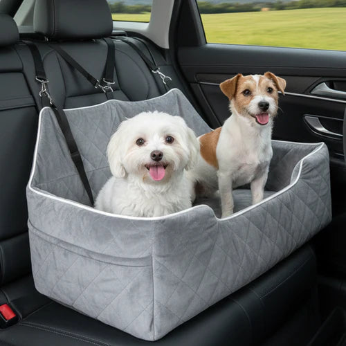 Two dogs in a gray pet seat in a car with a green field outside at Pet Servo