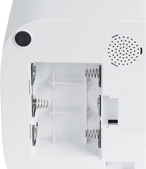 Close-up of the back of a white electronic device showing the battery compartment with exposed spring contacts and a circular speaker grille at Pet Servo