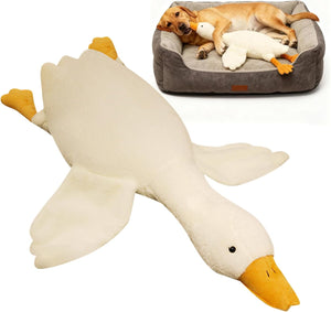 Large plush duck toy next to a dog lying on a bed with a duck-shaped pillow at Pet Servo