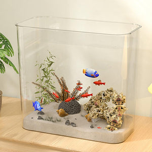 Small aquarium with decorative plants, rocks, and fish on a wooden surface at Pet Servo