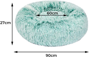 A fluffy round pet bed in a pale mint green color, shown with dimension arrows and labels indicating a height of 27cm, a width of 110cm, and a depth of 70cm at Pet Servo