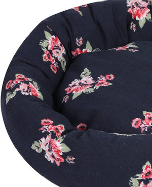 Close-up of a round pet bed or cushion with a dark navy-blue fabric and a red and pink floral print with green leaves, shown against a white background at Pet Servo