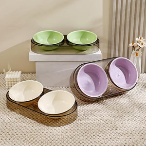 Set of pet bowls in green, white, and purple on a textured surface at Pet Servo