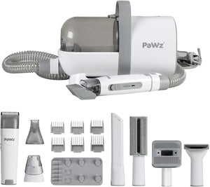 A white and gray pet grooming kit with a main canister unit, flexible hose, and multiple attachments including a trimmer, comb guards, brush, and grooming heads, shown on a plain white background at Pet Servo