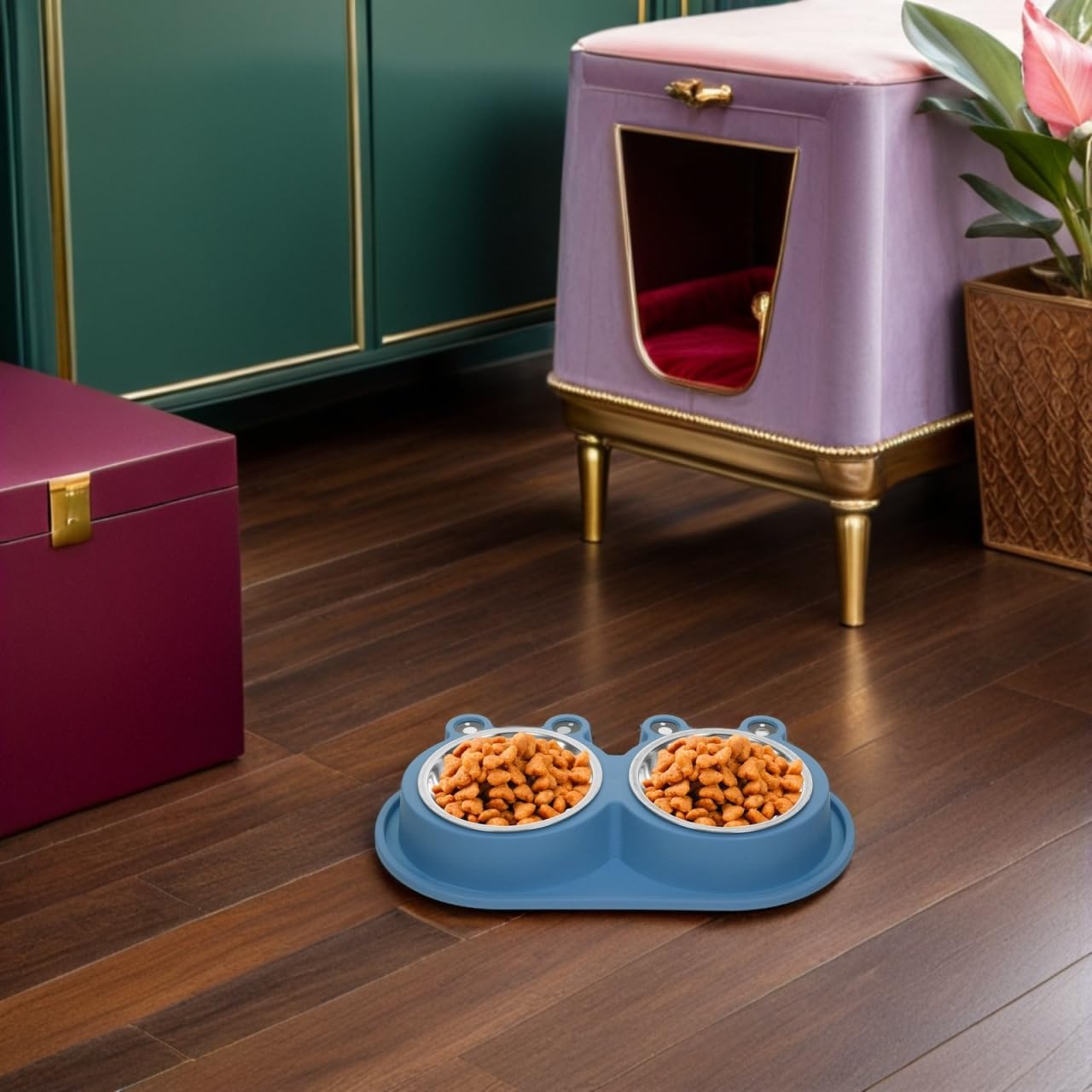 A blue dual pet feeder bowl filled with kibble sits on a dark wood floor in a styled room with a lavender pet house, green cabinets, and a magenta storage box at Pet Servo