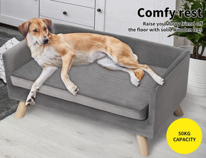 Dog lying on a gray pet bed with wooden legs in a home setting at Pet Servo