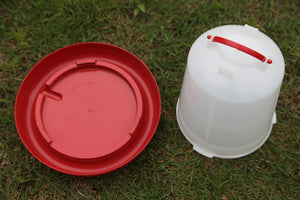 Red plastic lid and white plastic container with red handle on grass at Pet Servo