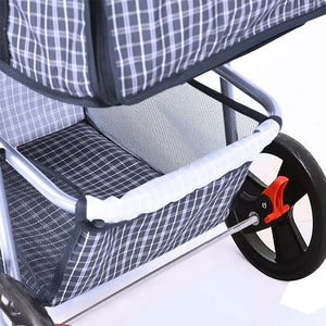 Close-up of a baby stroller or pram with a gray and white plaid fabric seat liner, mesh storage pocket, black wheels, and a silver metal frame at Pet Servo