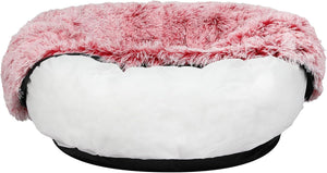 A round pet bed featuring a fluffy pink faux-fur top and a white plush cushioned base, with a black outer trim at Pet Servo