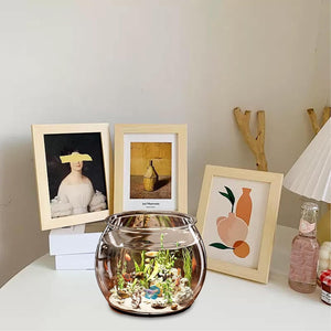 Decorative items including a fishbowl, framed pictures, and a lamp on a table at Pet Servo