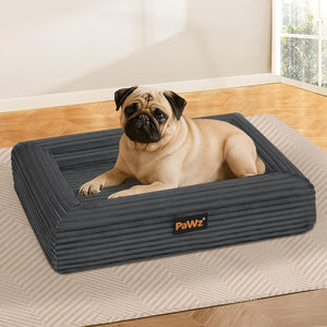Pug lying on a gray dog bed with 'PaWz' branding in a home setting at Pet Servo