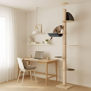 A tall cat tree in a light wood and beige fabric finish stands in a bright, modern home office. A brown tabby cat is sitting in a dark blue-gray hammock on the cat tree at Pet Servo