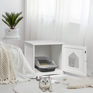Cat lying on a white floor next to a white pet enclosure with a gray litter box inside, in a bright room at Pet Servo