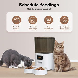 An automatic pet feeder shown with two cats in a home-like setting. The feeder is white with a dark gray hopper and a small digital display at Pet Servo