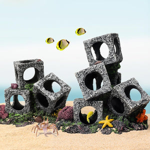 Aquarium decorations with stone blocks and marine life on a sandy bottom at Pet Servo
