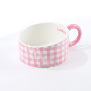 A pink and white checkered ceramic cup with a solid pink handle and interior, featuring the brand name 'Luksou' printed in pink on the inside, set against a plain white background at Pet Servo