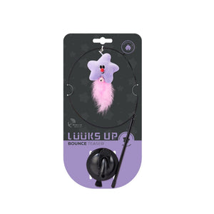 A cat toy package labeled 'LOOKS UP BOUNCE TEASER' showing a black circular rod with a purple star-shaped plush toy and pink fluffy tail, mounted on a black and lavender retail card at Pet Servo