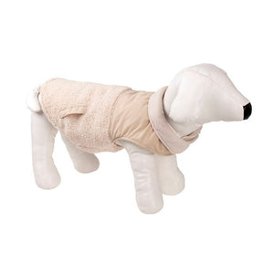 Dog wearing a beige fleece coat on a white background