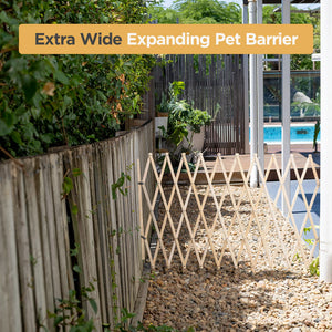 Extra wide expanding pet barrier in a garden setting with plants and a pool.