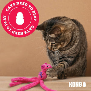 A brown tabby cat plays with a bright pink octopus-shaped plush toy on a light wood surface against a tan background. A red circular overlay reads 'CATS NEED TO PLAY CATS NEED TO PLAY' and the KONG brand name appears in the bottom right corner at Pet Servo