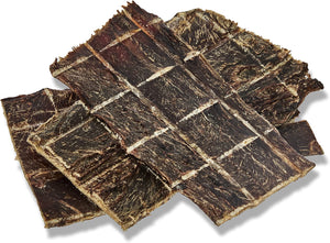 Several rectangular strips of dark brown dried jerky or beef jerky arranged overlapping on a white background with a soft drop shadow.