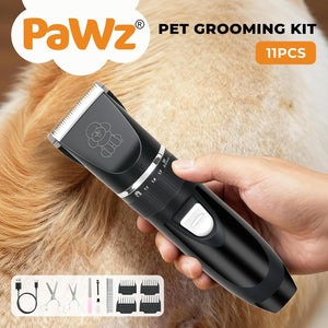 A handheld black pet grooming clipper being used on a golden cat, with a human hand holding the device. The image includes the text 'PaWz PET GROOMING KIT', '11PCS', and a small accessory icons panel at the bottom showing included items like a cord, scissors, comb guards, and a brush at Pet Servo