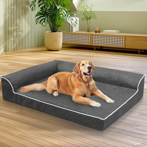 Dog lying on a large gray pet bed in a room with plants and furniture at Pet Servo
