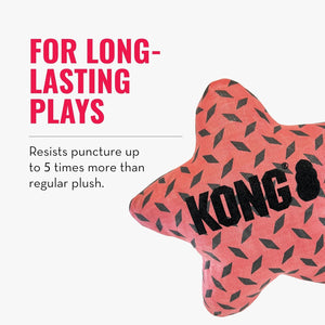 A KONG star-shaped dog toy in coral pink with a black diamond pattern and black brand text, shown on a light gray background with promotional text reading 'FOR LONG-LASTING PLAYS' and 'Resists puncture up to 5 times more than regular plush.' at Pet Servo