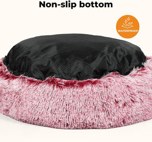A pet bed with a fluffy pink faux-fur exterior and a black non-slip bottom, shown on a light beige background with text reading 'Non-slip bottom' and a circular 'Waterproof' badge at Pet Servo
