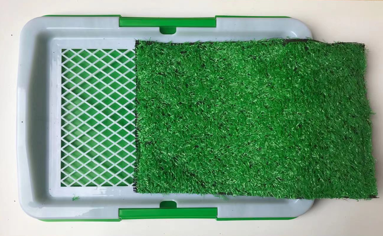 Green artificial grass mat with a white border on a light gray background at Pet Servo