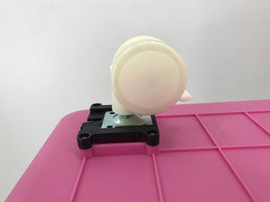 White circular object on a pink grid with a white background at Pet Servo
