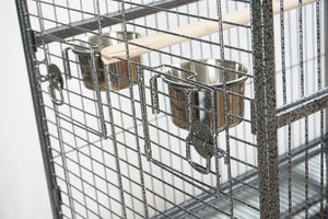Close-up of a bird cage with perches and a water dish on a white background at Pet Servo