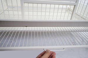 Hand holding a white metal shelf against a white background at Pet Servo