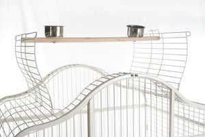 Wire pet cage with a wooden shelf and metal bowls on a white background at Pet Servo