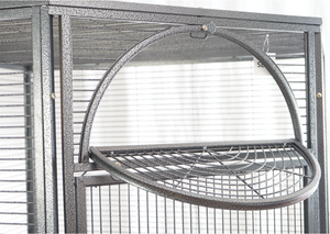 Bird cage with a round perch inside, against a window background at Pet Servo