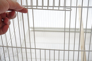 Hand holding a wire cage with a blurred background at Pet Servo