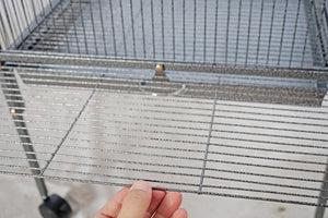 Metal wire mesh of a cage held by a hand at Pet Servo